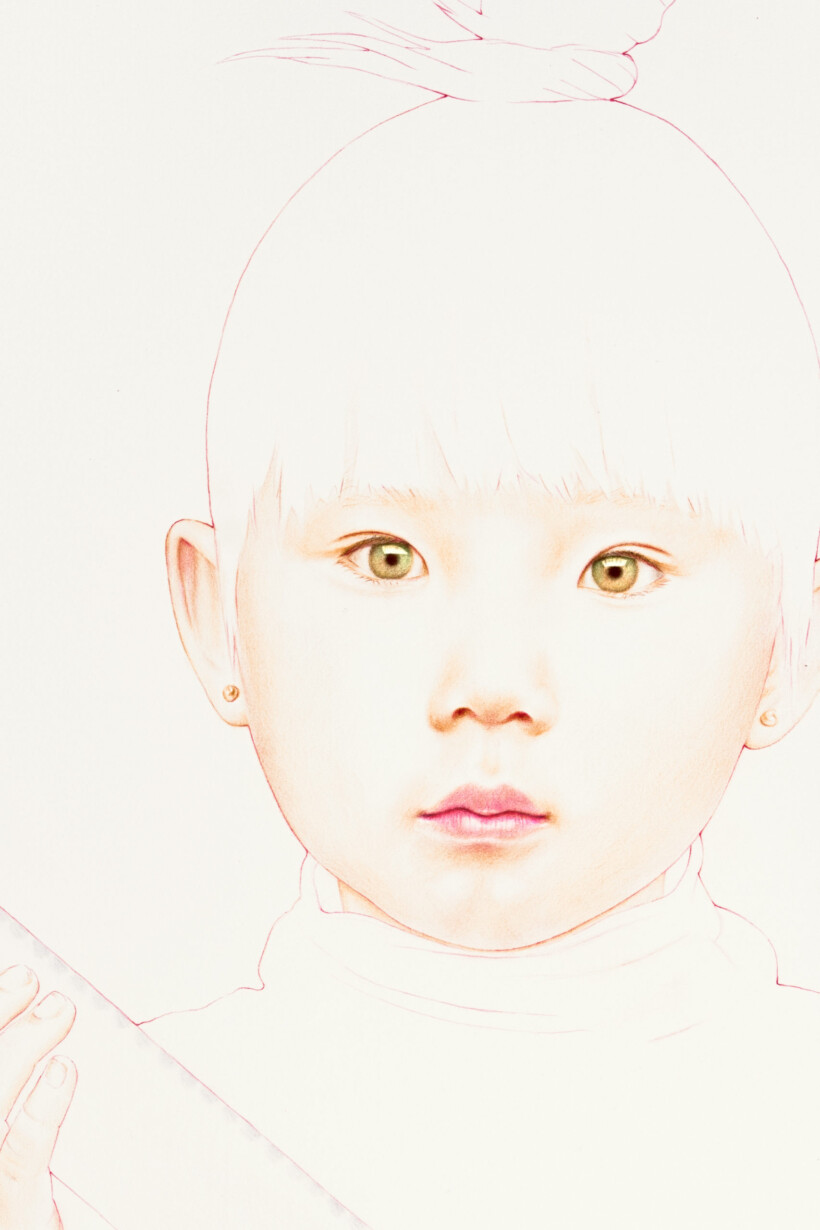 Primer plano de un niño con moño y aretes pequeños.