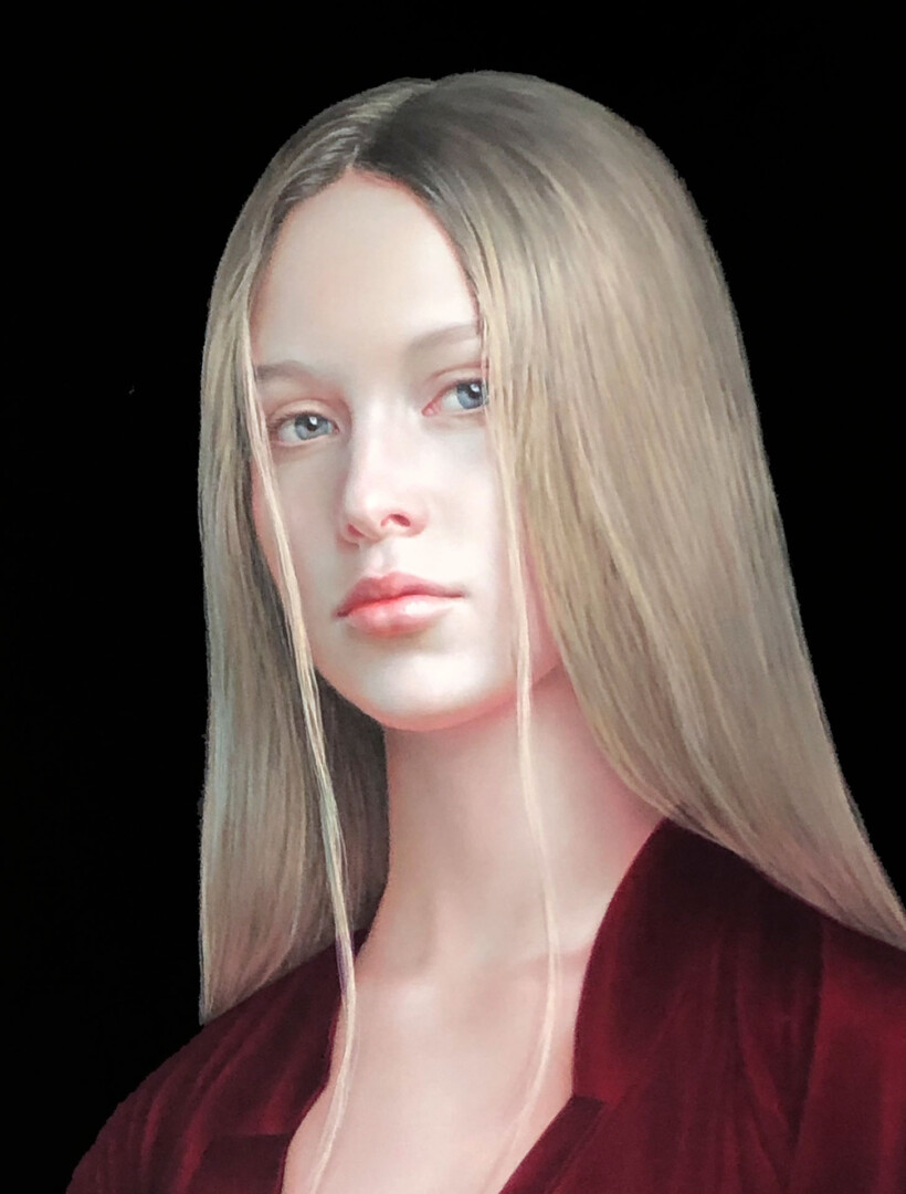 Retrato de una joven rubia con vestido granate y cabello suelto.