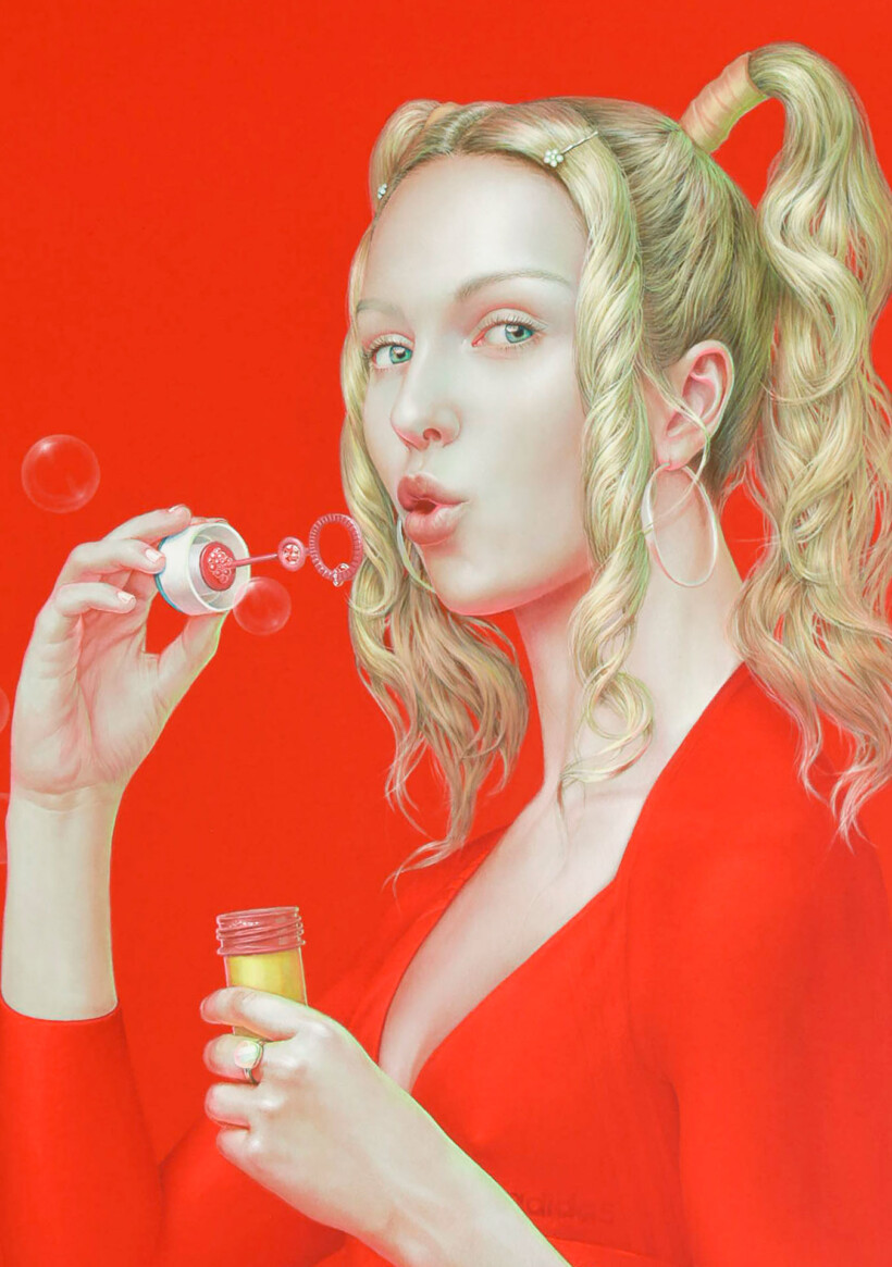 Un retrato de una mujer soplando pompas de jabón. La figura tiene el pelo recogido en dos coletas y viste una blusa de color rojo intenso. El fondo es de un rojo brillante.