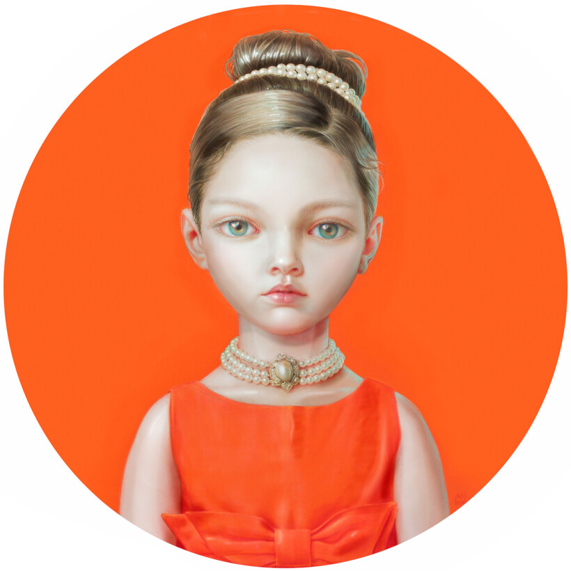 Retrato de busto de una niña con pelo recogido, ojos verdes y un vestido naranja, en un círculo del mismo color.