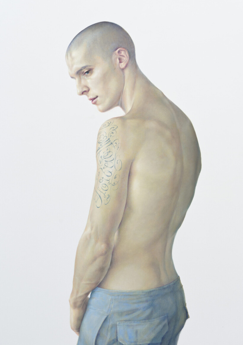 Pintura realista de un joven con la cabeza rapada, visto desde la espalda, con un torso desnudo. Viste unos pantalones de trabajo de color azul y tiene un tatuaje en el brazo izquierdo. El fondo es completamente blanco.